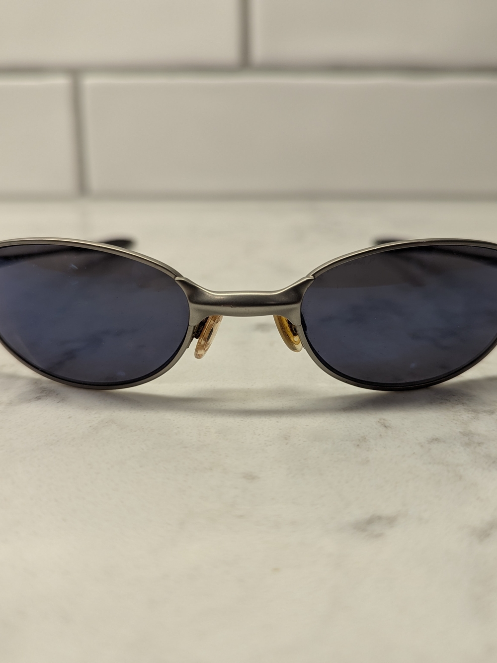 Oakley Oval Metal Sunglasses in Gunmetal with Blue Lenses